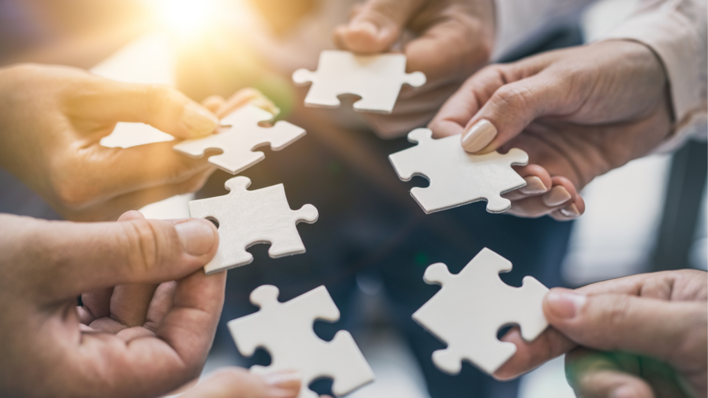 Business image of people working together on a puzzle.